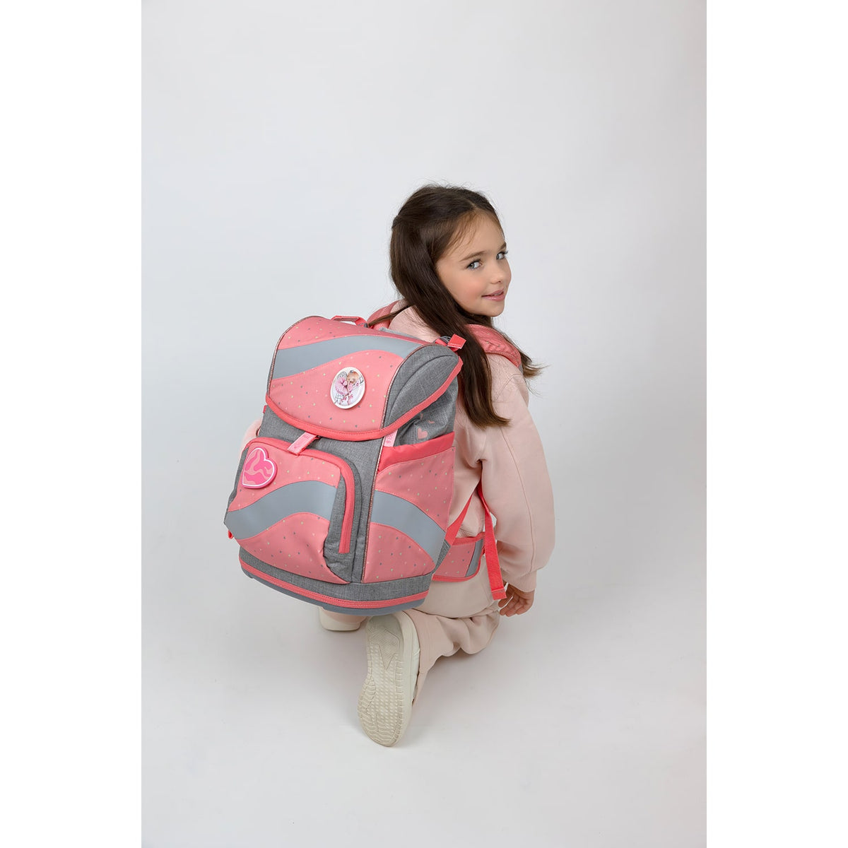 The Belmil Smarty Minimal Triangels Ergonomic School Bag Set – 5-Piece Set with 9 Interchangeable Patches and Hip Belt on a smiling girl, highlighting the backpack’s colorful patches and ergonomic features.