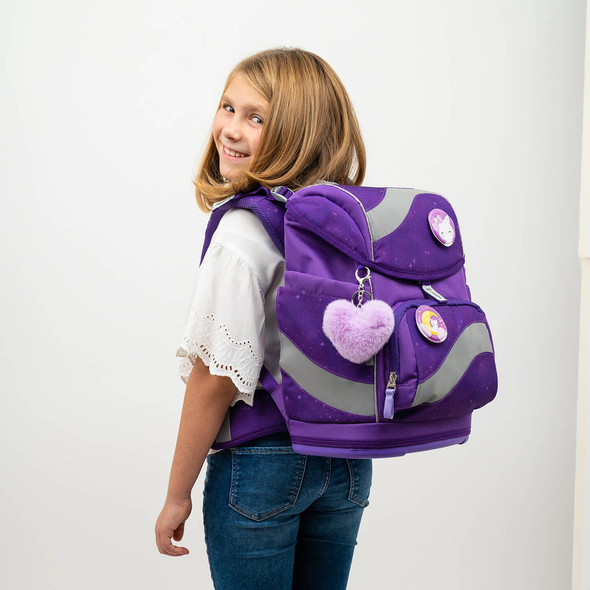 A happy girl wearing the Belmil Smarty Purple Sky Ergonomic School Bag Set – 5-Piece Set with 9 Interchangeable Patches and Hip Belt, showing off her school style with fun patches on this ergonomic bag. Perfect for girls attending school in 2025, on SALE now!